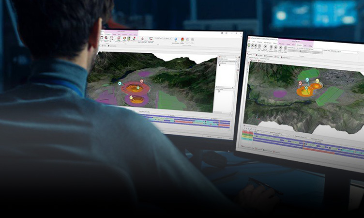 Man using software on two computer screens